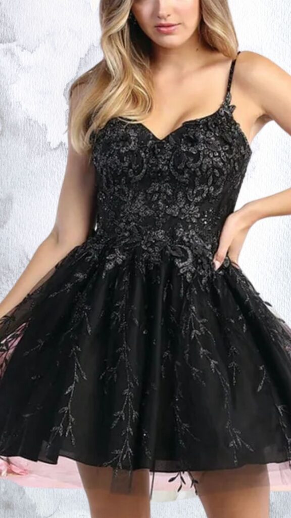 The dress features a fitted bodice with intricate bead and sequin embellishments, showcasing a sweetheart neckline and delicate spaghetti straps. The skirt flares out in a playful A-line silhouette, layered with black mesh adorned with subtle floral designs, ending just above the mid-thigh for a youthful, elegant look. The overall design combines glamour with a flirtatious charm, perfect for special occasions.