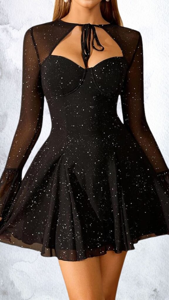This black mini dress features a fitted bodice with a sweetheart neckline and playful cutouts at the shoulders, adorned with shimmering rhinestones for an eye-catching effect. Long, sheer mesh sleeves add a dramatic touch, while the flared skirt creates a flattering silhouette that falls mid-thigh, accentuating movement and elegance. The dress is finished with a hemline that flows gracefully, making it suitable for both casual and formal occasions.
