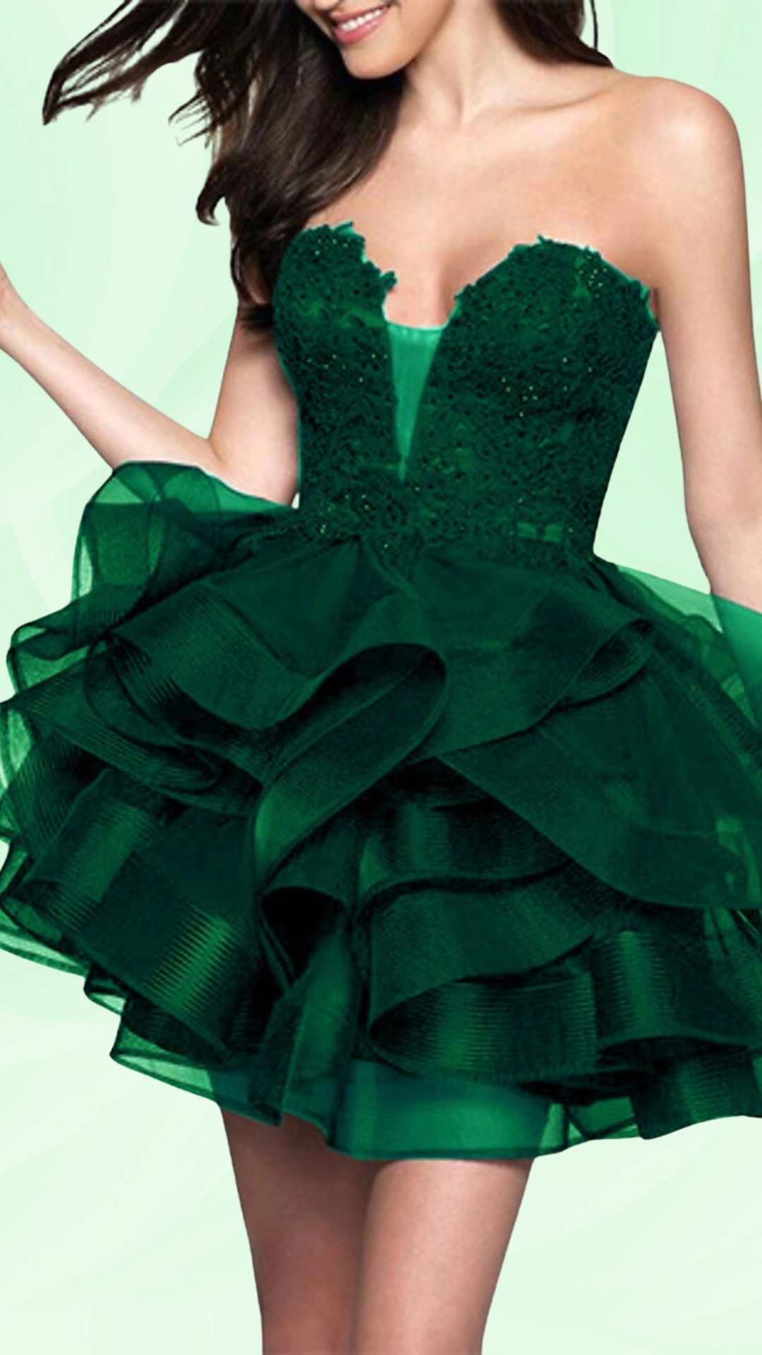This emerald green homecoming dress features a fitted corset-style bodice adorned with intricate beading, leading to a voluminous, layered ruffle skirt that adds playful texture. With its eye-catching color and flirty silhouette, this dress embodies a romantic and trendy vibe, perfect for formal events like homecoming or school dances, tailored for teenagers.