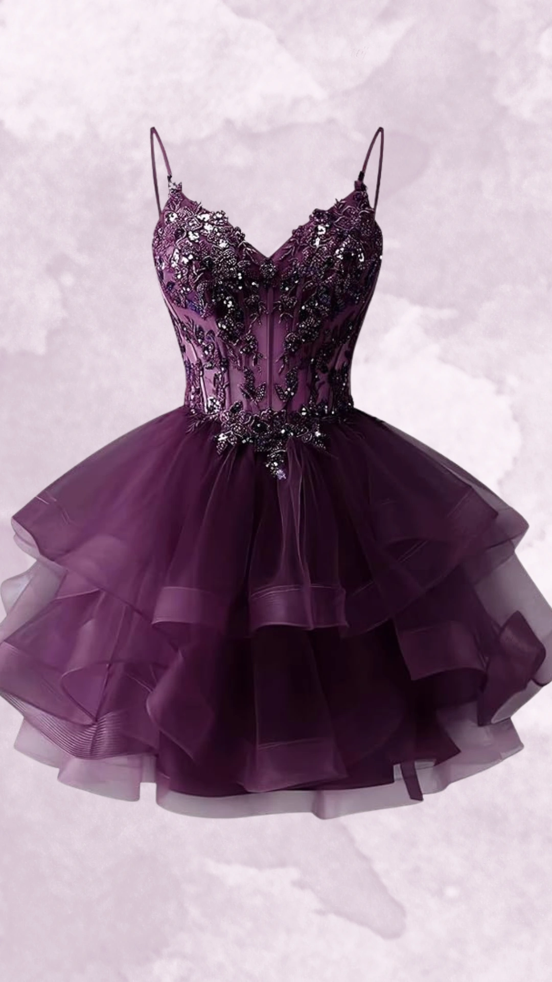 This stunning homecoming dress features a fitted bodice adorned with intricate black beading and a flared, layered skirt made from soft tulle, presenting an enchanting deep purple hue. With its playful silhouette and a stylish combination of glamour and whimsy, this dress is perfect for teens attending formal events like homecomings or prom.