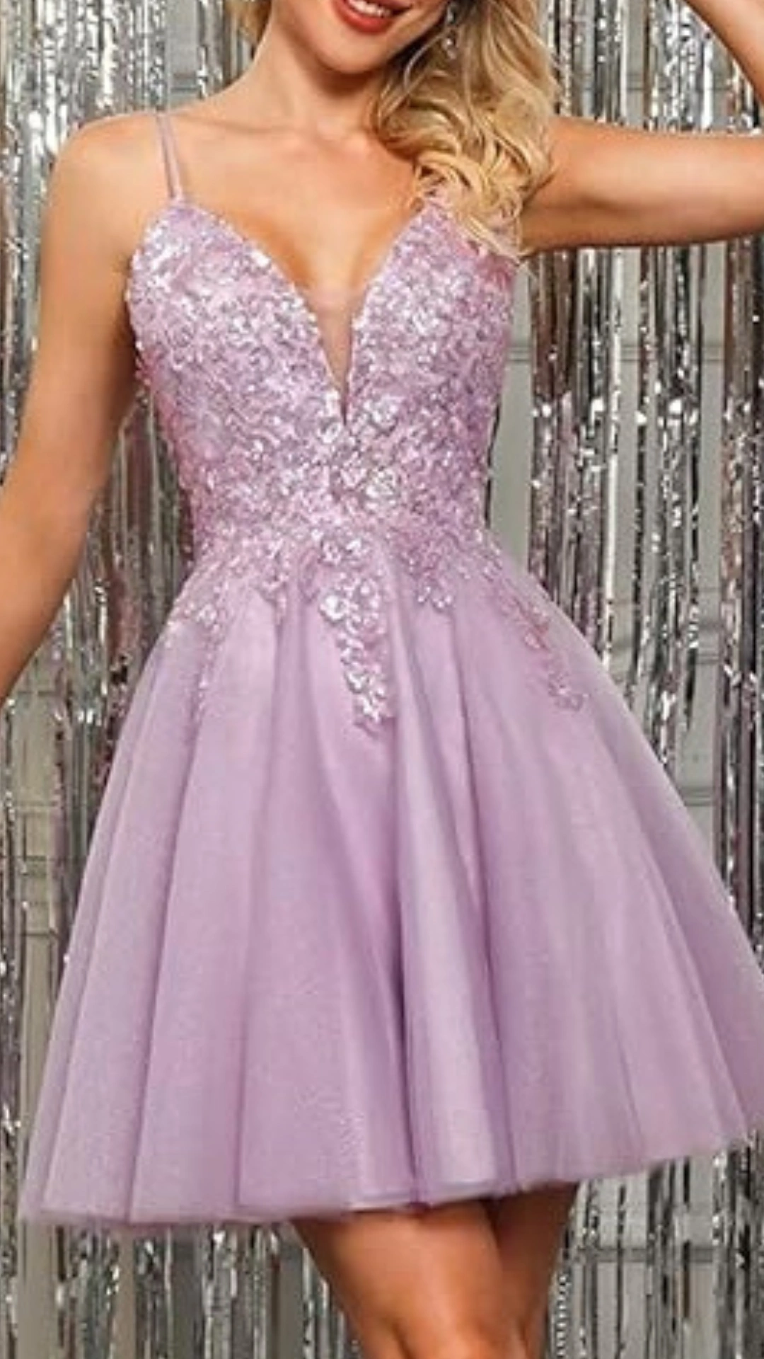 This enchanting homecoming dress features a delicate lilac hue with intricate floral beadwork adorning the fitted bodice, creating a striking V-neckline. The flowy, voluminous skirt offers a playful silhouette, perfect for a formal school dance, radiating a romantic and youthful vibe ideal for teens.