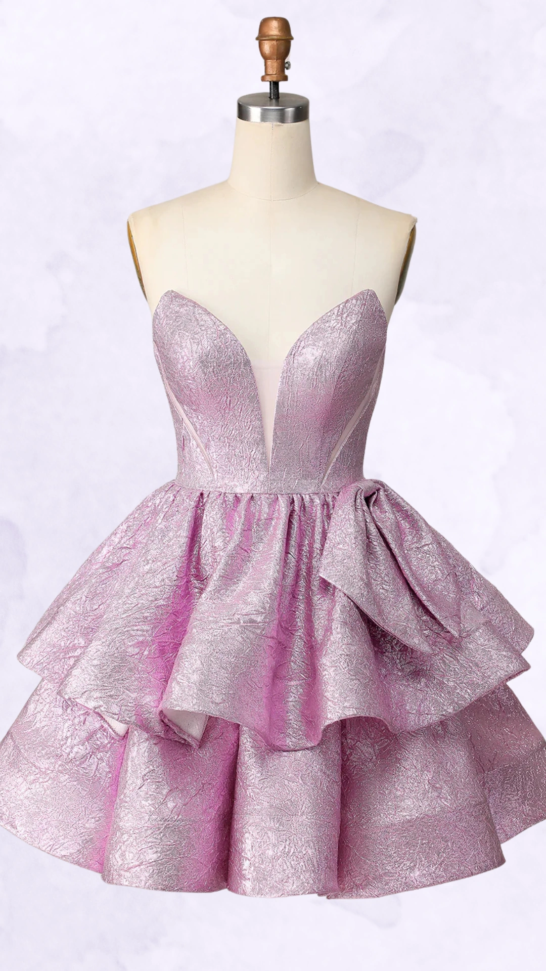 This homecoming dress features a structured, sweetheart neckline with intricate detailing and a playful, voluminous skirt, crafted from a textured, shimmering lilac fabric. The design exudes a trendy and youthful vibe, perfect for formal events or school dances, tailored for teenage girls seeking a bold and fun statement piece.