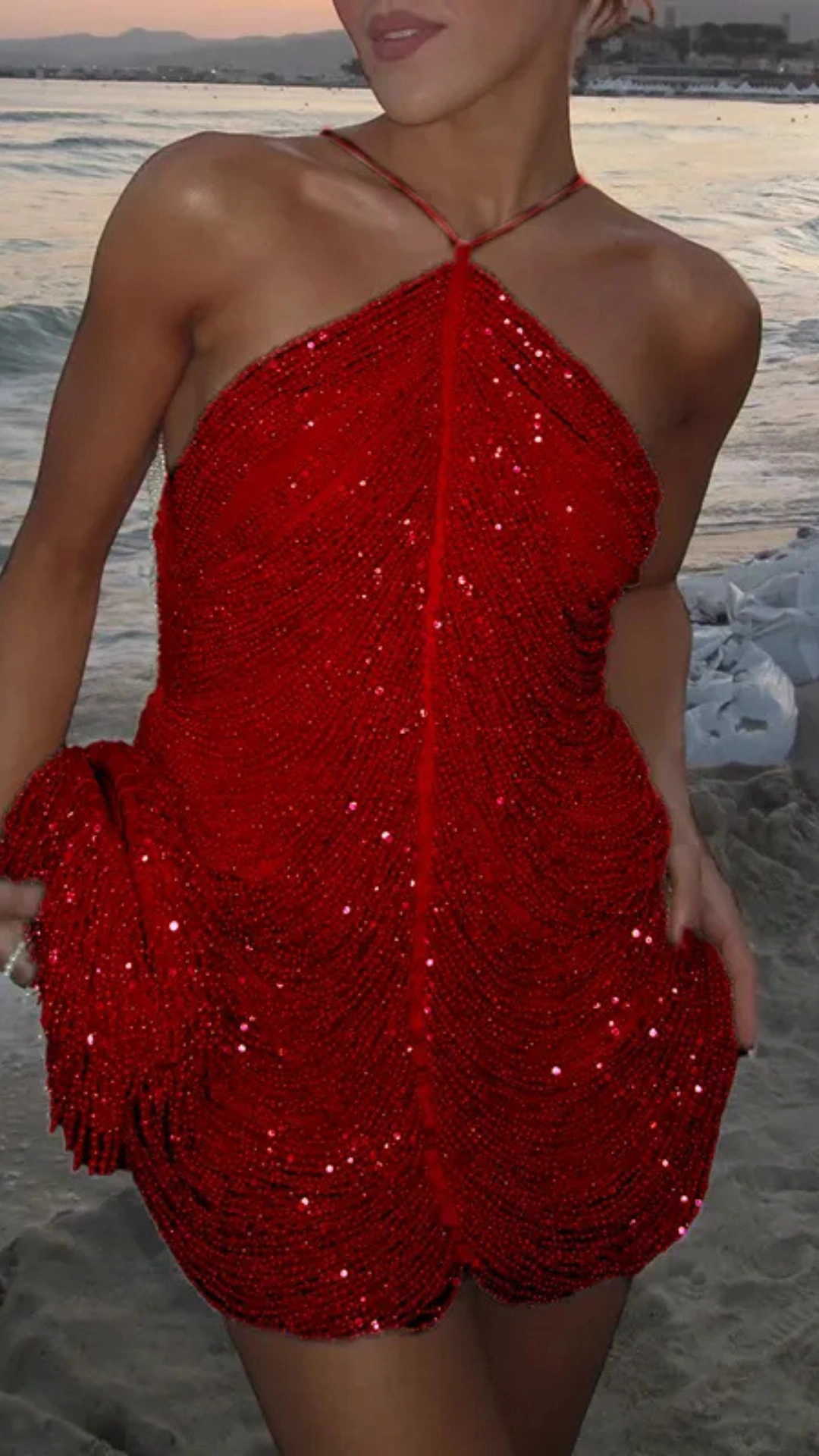 This striking red homecoming dress features a sleek strapless design with a fitted silhouette that accentuates the body, adorned with shimmering sequins that create a textured, glimmering effect. Perfect for a formal event or dance, it exudes a bold, glamorous vibe, making it an ideal choice for teens seeking a standout look.