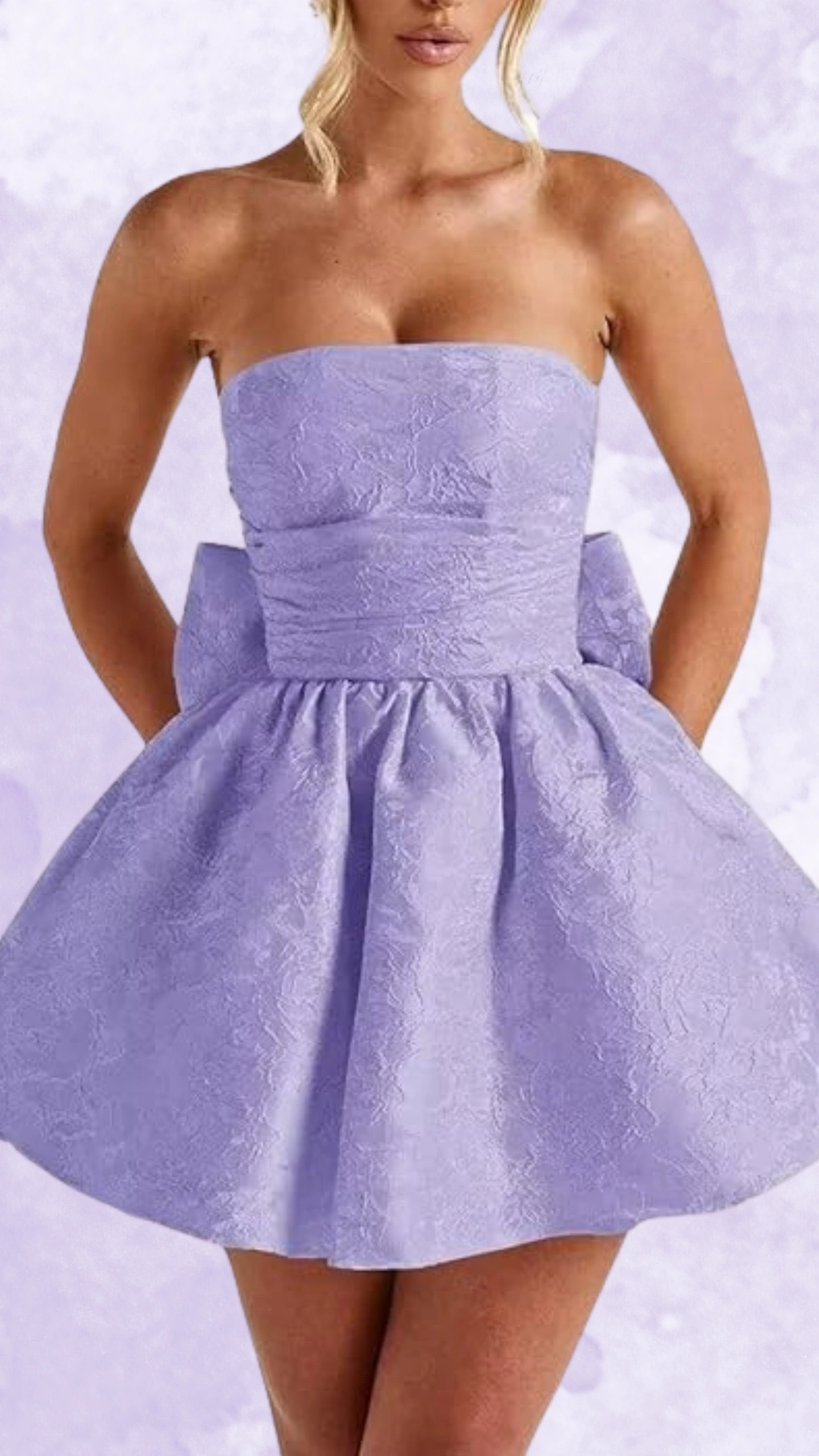 This strapless homecoming dress features a light lavender hue with a textured fabric that adds a subtle elegance, accentuated by a fitted bodice and a voluminous skirt that flares out stylishly. The overall vibe is youthful and playful, making it perfect for a festive event like homecoming or a school dance, appealing to teenage girls seeking a chic and fun look.