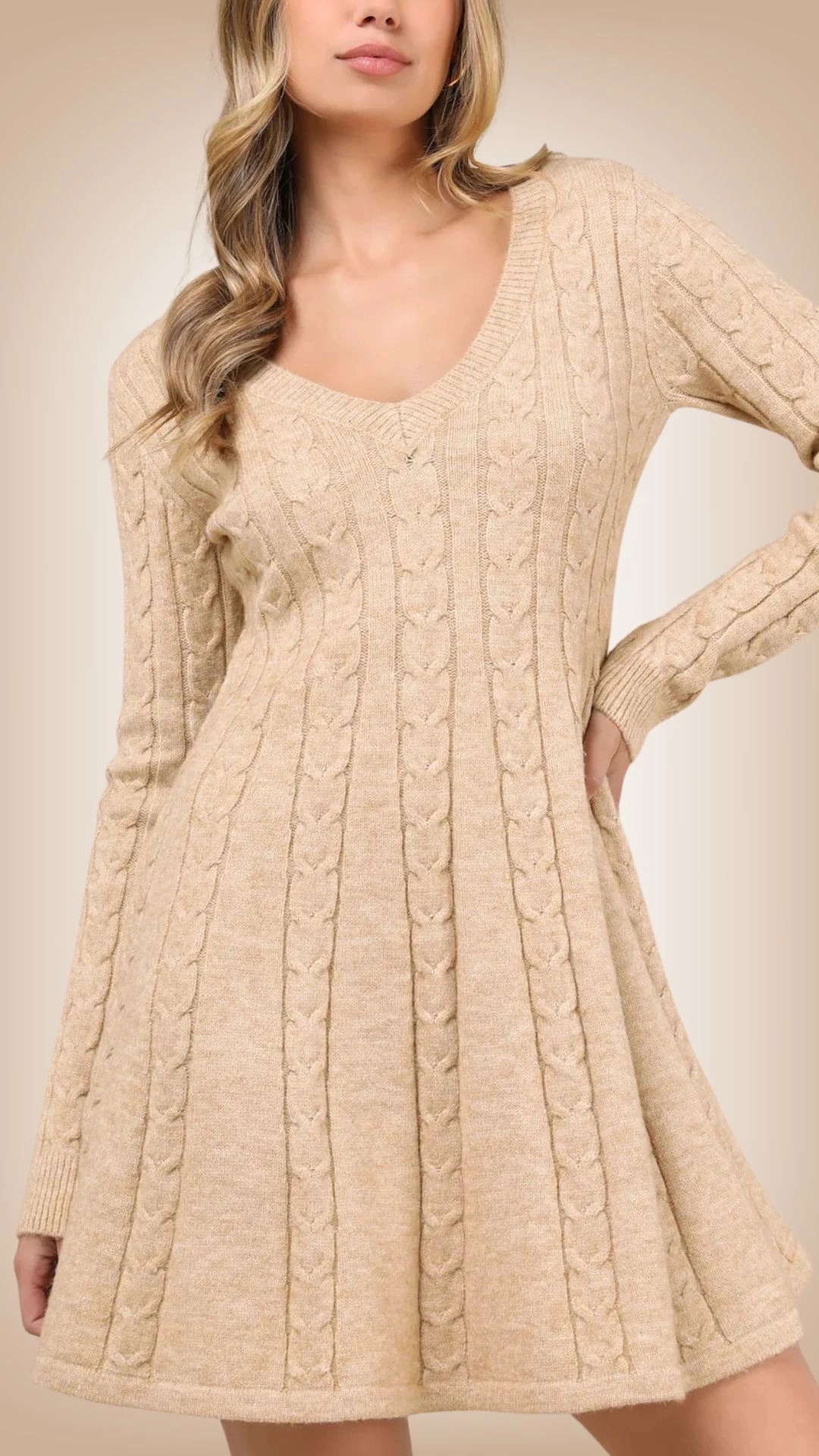 This sweater dress features a cozy, cable-knit design with vertical patterns that create a textured appearance. It is a soft, warm beige color, complemented by a deep V-neckline and long sleeves, providing both comfort and style. The flared fit gently skims the body, offering a flattering silhouette that transitions smoothly from the waist to the hem.