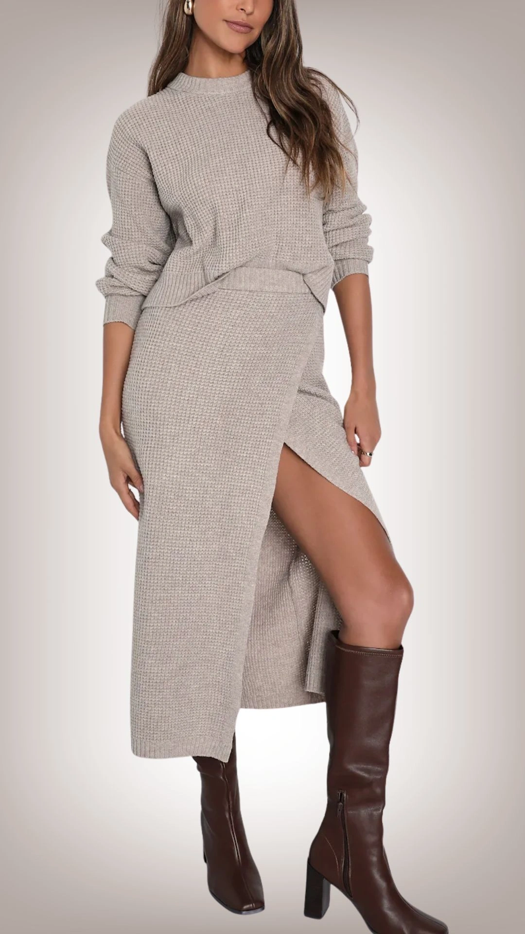 The sweater dress features a soft, ribbed texture in a neutral shade of light beige, with a relaxed fit at the bodice and a form-fitting silhouette that drapes elegantly over the body. It includes a thigh-high side slit for added allure and is styled with long, slightly puffed sleeves, contributing to a cozy yet sophisticated appearance. Paired with knee-high, sleek brown leather boots, this outfit embodies a chic, layered look ideal for cooler weather.