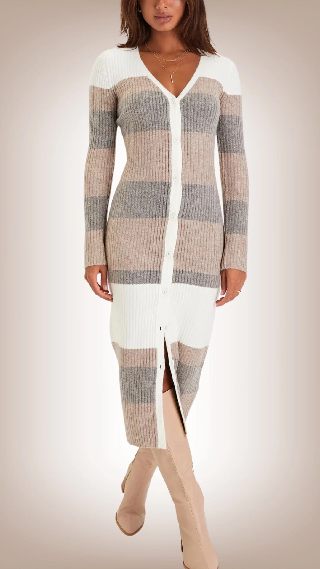 The sweater dress features a fitted silhouette with ribbed texture, showcasing a stylish mix of color-blocked stripes in soft beige, gray, and white. It has a deep V-neckline and a button-down front, creating a sleek look, while a thigh-high slit adds a modern flair. The long sleeves and body-hugging fit provide warmth and comfort, making it suitable for various occasions.