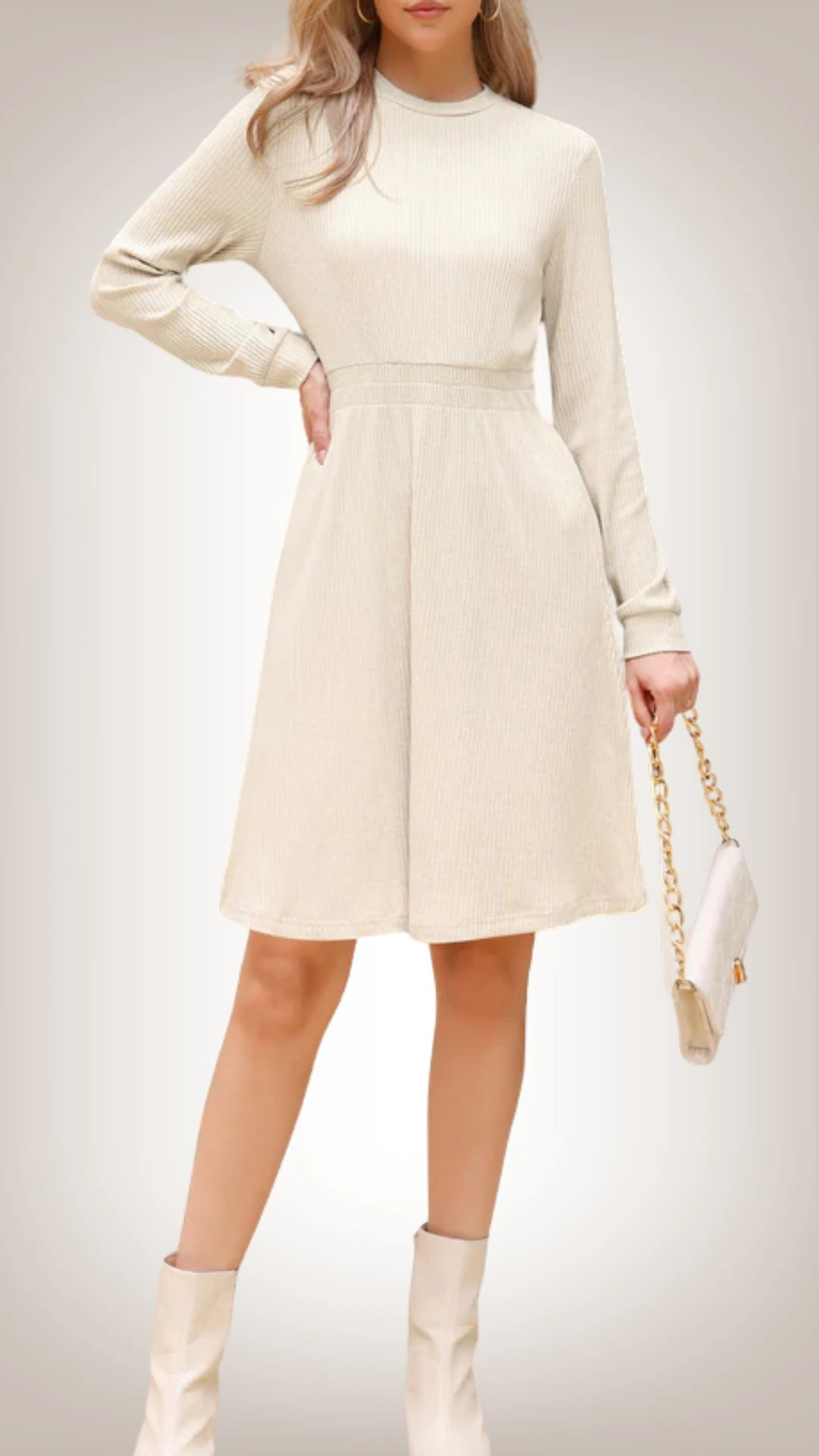 This sweater dress features a fitted bodice with a high neckline and long sleeves, transitioning into a flowing A-line skirt that falls above the knees. It is crafted from a soft, ribbed fabric in a light beige color, offering a casual yet chic appearance. The subtle texture and comfortable fit make it suitable for various occasions, while its relaxed silhouette enhances mobility.