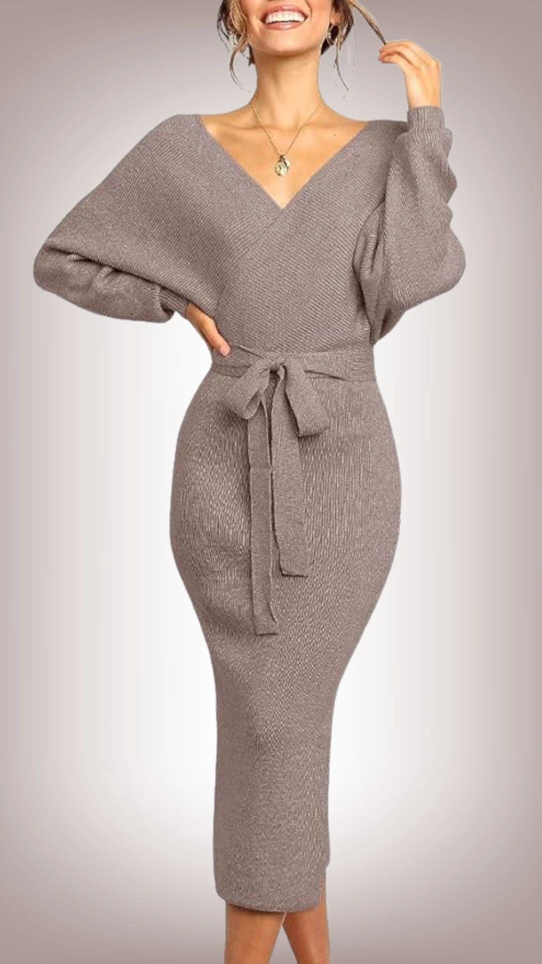 The sweater dress features a snug, body-hugging silhouette with a soft, stretchy knit fabric in a warm taupe color, accented by a flattering V-neckline and voluminous, dropped shoulders. It is cinched at the waist with a coordinating tie belt, enhancing the feminine shape, and falls to a midi length, offering a chic, sophisticated look suitable for various occasions. This versatile dress combines comfort with style, making it perfect for layering or wearing alone.