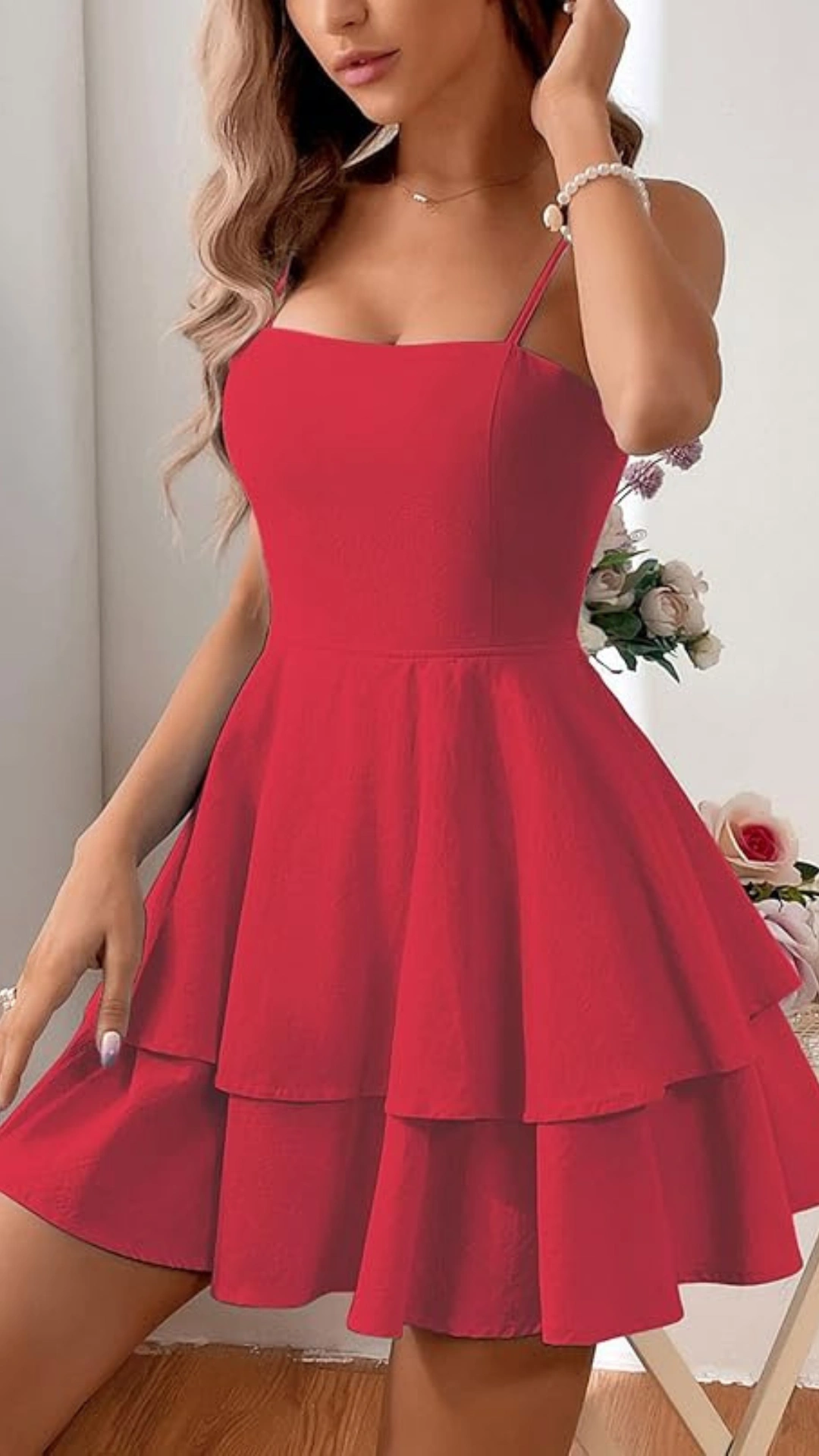 This vibrant red homecoming dress features a fitted bodice with spaghetti straps and a playful tiered skirt, crafted from a lightweight, slightly textured fabric that adds depth. With its youthful and flirty vibe, this dress is perfect for formal events like homecoming or school dances, designed specifically for teens seeking a fun, stylish look.
