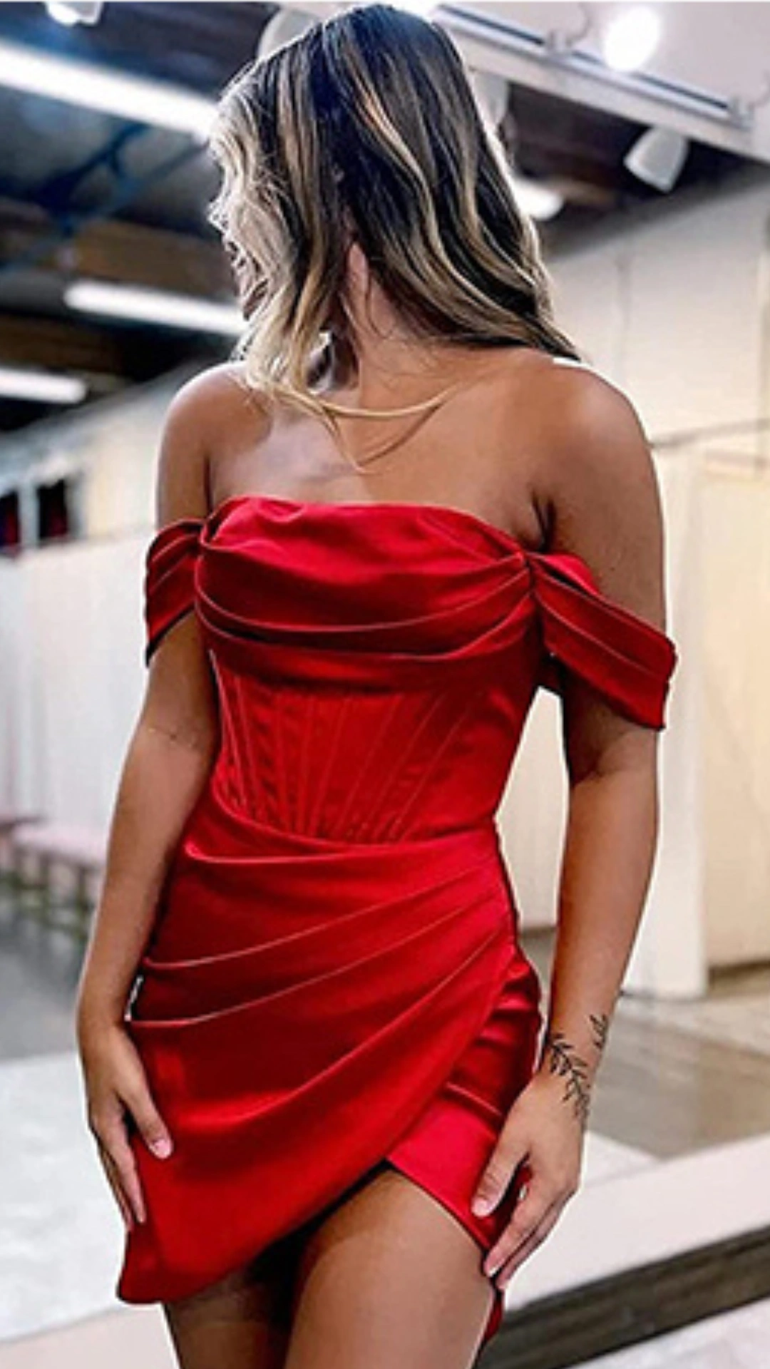 This vibrant red off-the-shoulder homecoming dress features a sleek satin fabric that provides a smooth, luxurious texture, complemented by intricate seam detailing that accentuates the corset-inspired bodice. The form-fitting silhouette culminates in a playful, draped mini skirt that offers a bold and trendy vibe, making it a perfect choice for a festive homecoming celebration aimed at teen girls.