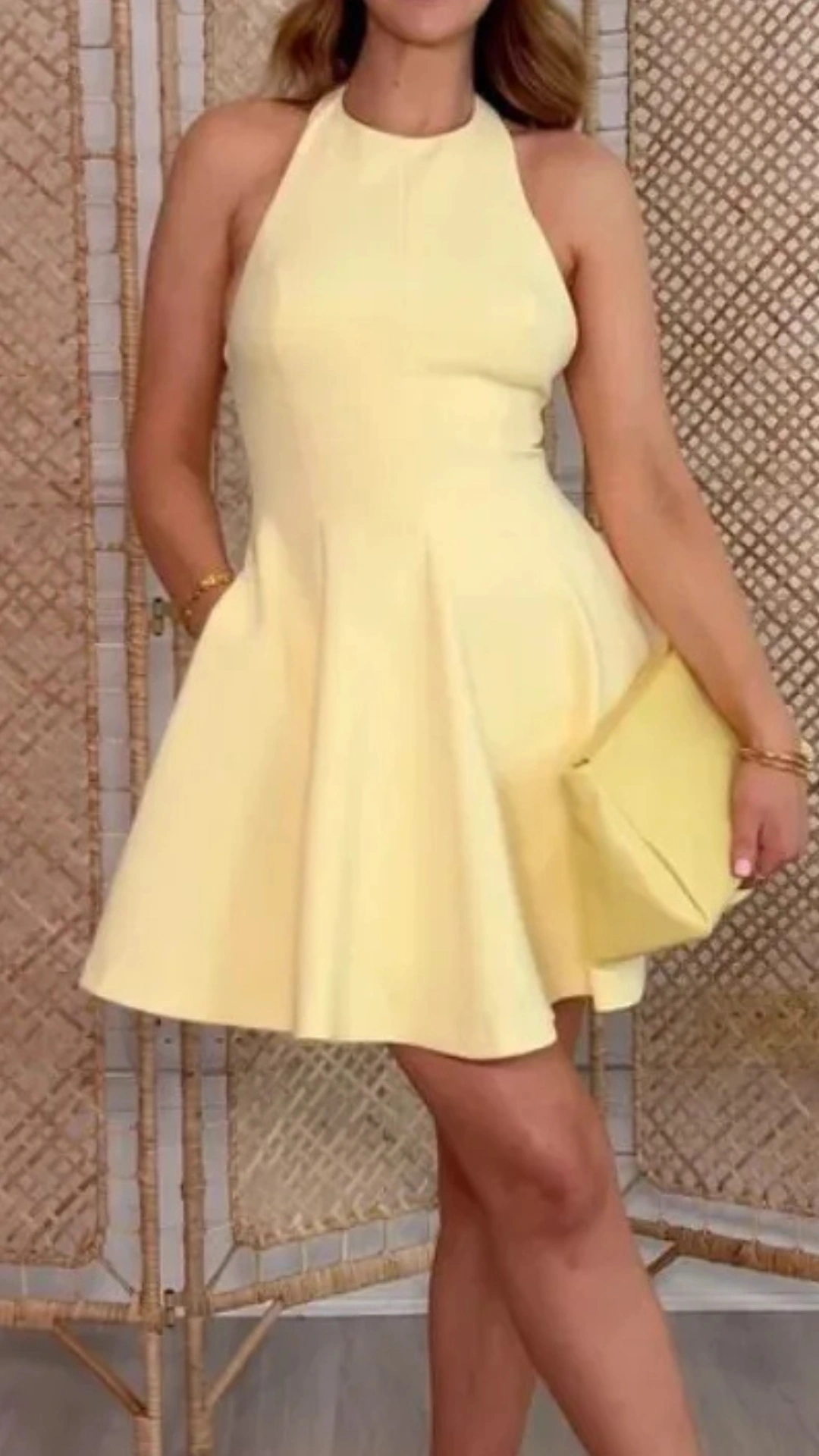 This bright lemon yellow homecoming dress features a fitted halter neck style with a flared skirt that falls above the knee, crafted from a smooth, structured fabric that adds subtle volume. Its simple yet chic design embodies a youthful, trendy vibe, making it perfect for a teenage girl attending a fun homecoming or school dance.